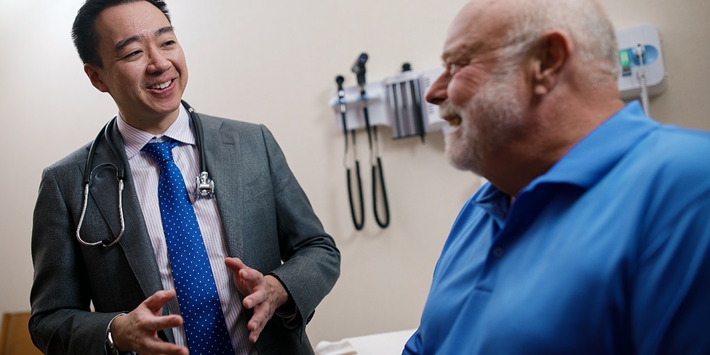 Geriatric physician converses with patient