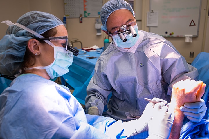 Mayo Clinic surgeons in an operating room performing hand surgery.