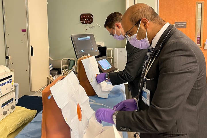 Two doctors from the Hematology/Oncology Fellowship program in Jacksonville, Florida, are performing a training lab exercise.