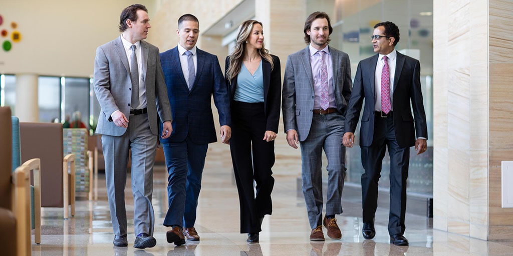 Infectious disease fellows and faculty walk down a hallway together at Mayo Clinic