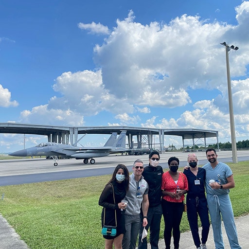 Internal Medicine residents posing for a group photo in front of an aircraft during their four-week Aerospace Medicine elective.