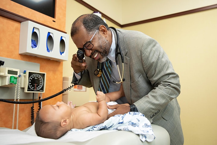 Dr. Richard White, Chair of Community Internal Medicine, examines a patient