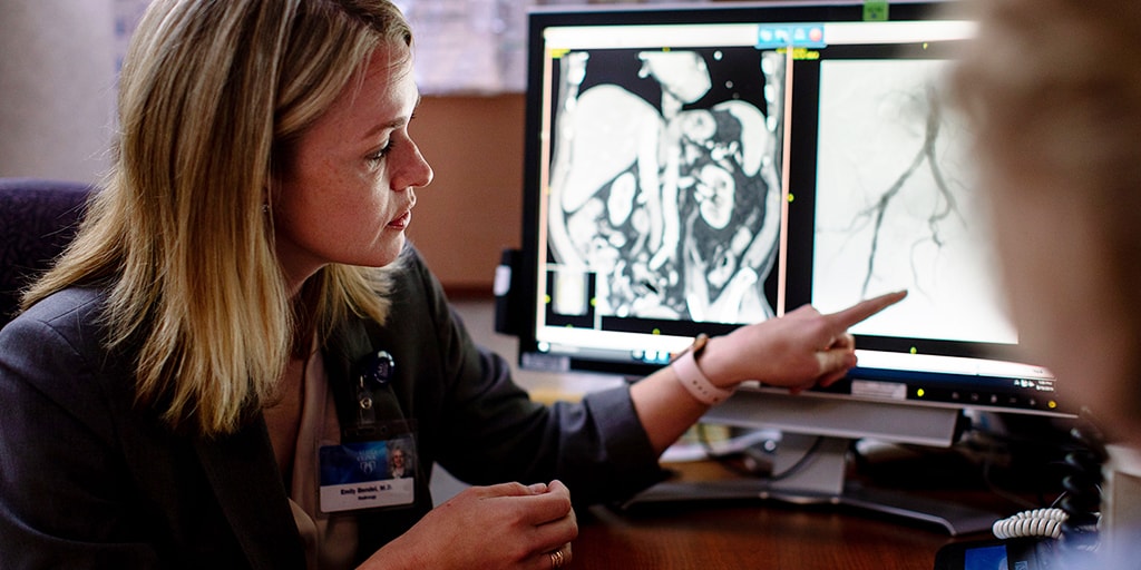 Interventional radiology resident looks at a scan with a patient at Mayo Clinic in Rochester, Minnesota.