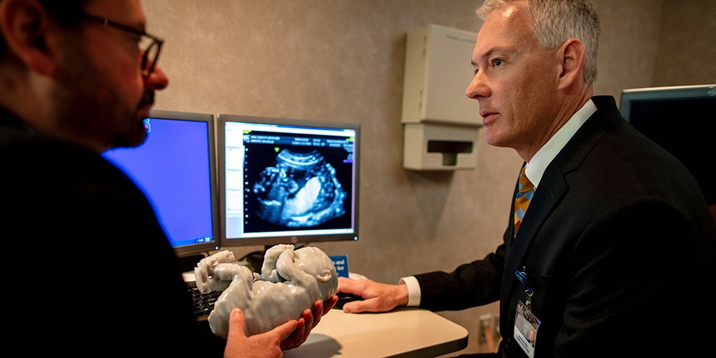 Fetal medicine physicians examining a model of a fetus with an ectopic heart