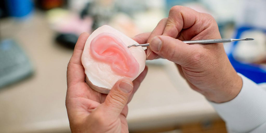 Faculty demonstrating imaging technique with ear mold at Mayo Clinic in Rochester, Minnesota.