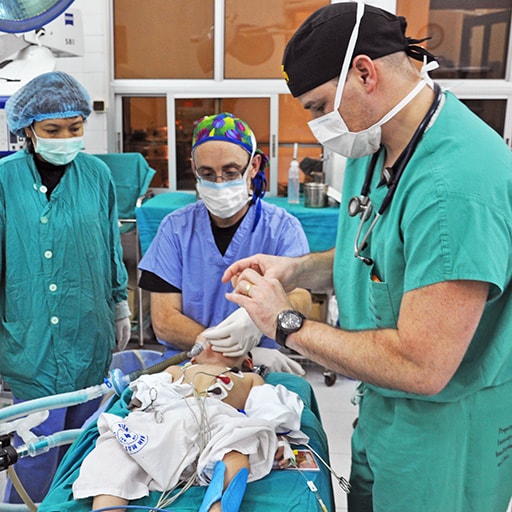 Mayo International Health Program medical staff in an operating room doing a procedure for a patient.