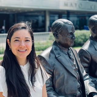 Dr. Encalada posing with Mayo brothers statue outside of Mayo building