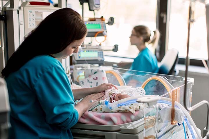 Fellow checking on a patient in the NICU