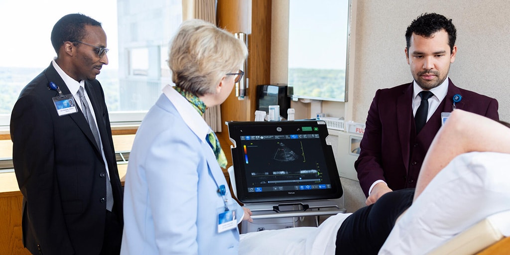 Iasmina Craici, MD, Nephrology consultant and fellowship program director, supervises and views a monitor as a Nephrology fellow performs an ultrasound on a patient and another fellow observes