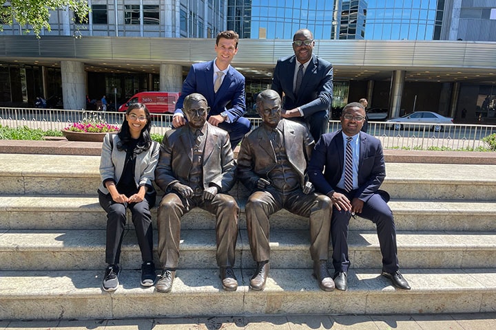 Neurosurgery residents sitting with the Mayo Brothers statues