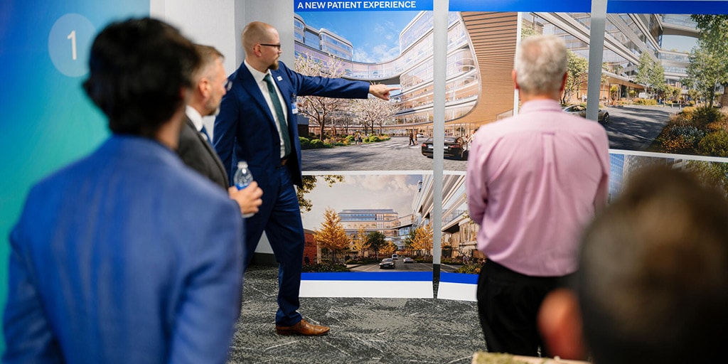 Man points to renderings of plans to renovate downtown Rochester.