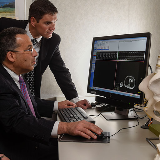 Physicians examining neurological and orthopedic scans