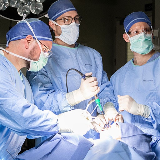 Surgeons completing a skull base surgery in the operating room