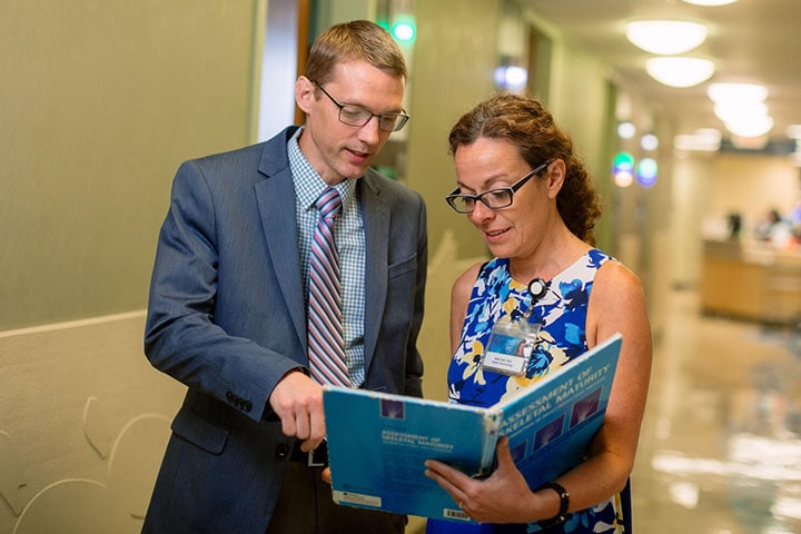 Pediatric fellow collaborates in the hallway with a colleague