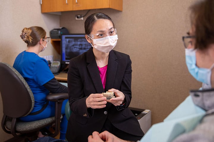 Cindy Zhou, D.M.D., M.S. explains dental implants to patient at Mayo Clinic in Rochester, Minnesota.