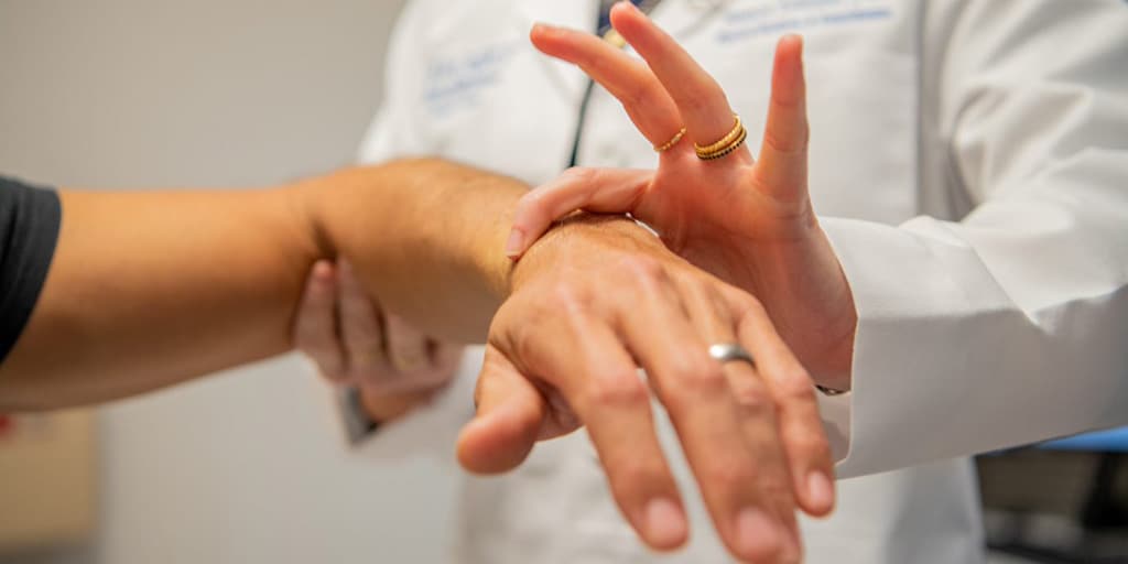 Physical Medicine and Rehabilitation Residency doctor examines a patient's wrist.