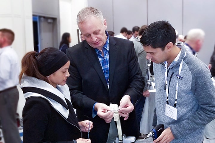 Plastic Surgery residents speaking with a representative at a conference.
