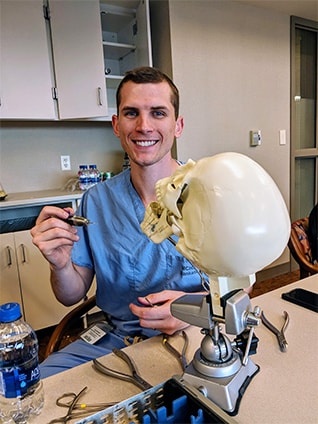 Plastic surgery resident working with a skull model.