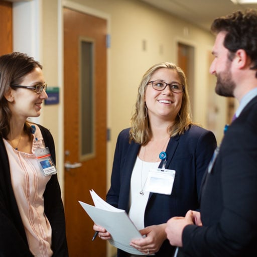 A group of psychiatry residents talk in the hall outside of class.