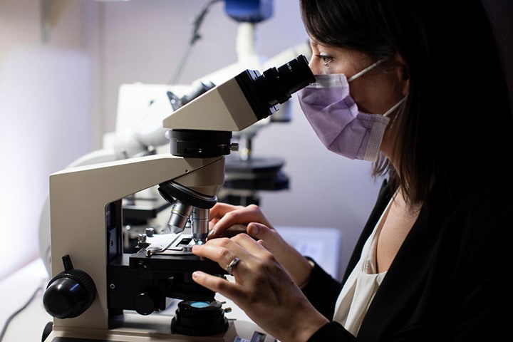 A fellow in the Rheumatology Fellowship at Mayo Clinic in Rochester, Minnesota, views tissue sample with a microscope.
