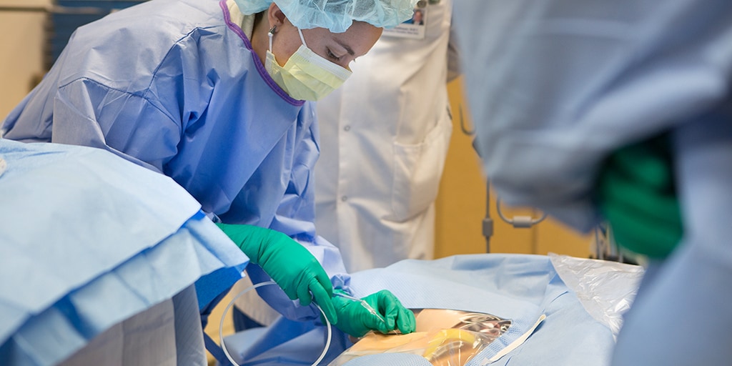 Surgical critical care fellows perform a procedure