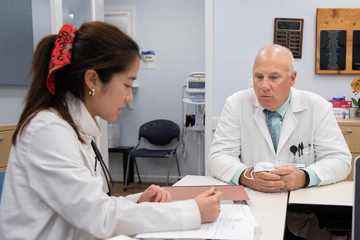 Mayo Clinic Alix School of Medicine student studying sitting next to her mentor at a table at Mayo Clinic's campus in Jacksonville, Florida.