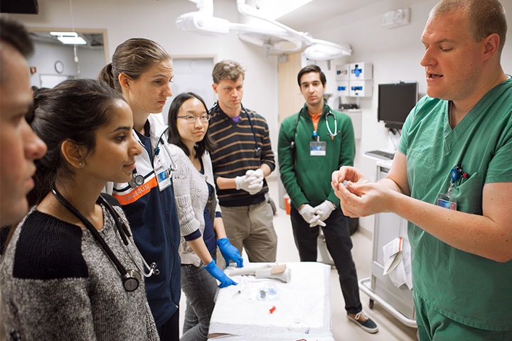 Mayo Clinic School of Medicine students observing a faculty member in simulation center