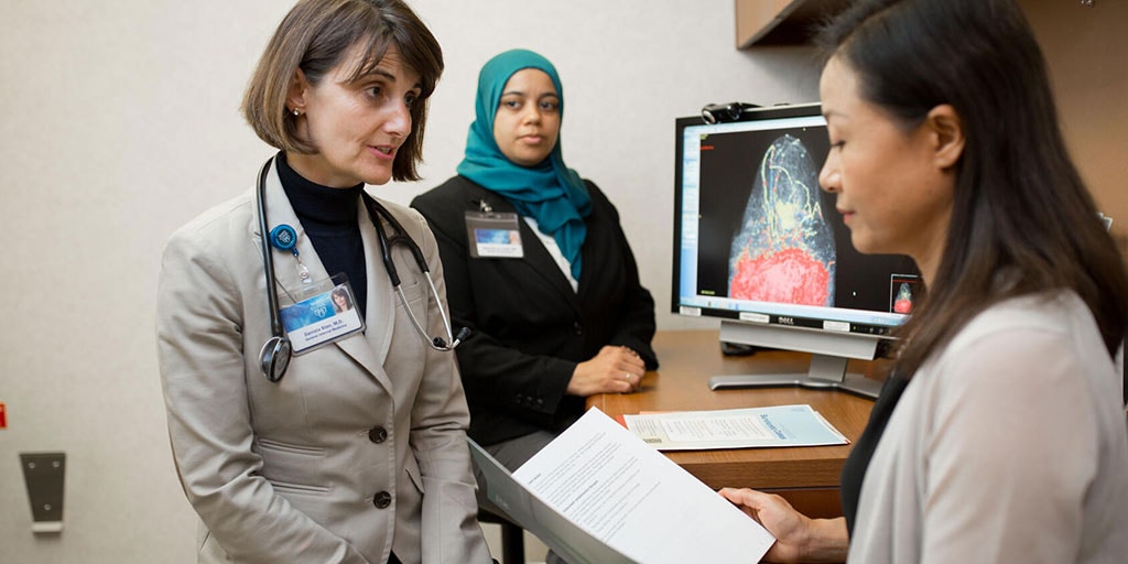 Physicians meet with a patient