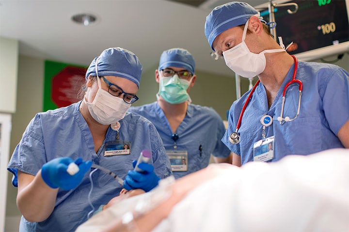 Anesthesiologists performing a procedure on a mannequin