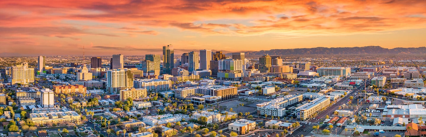 A colorful sunrise is shown over an Aerial view of downtown Phoenix, Arizona.