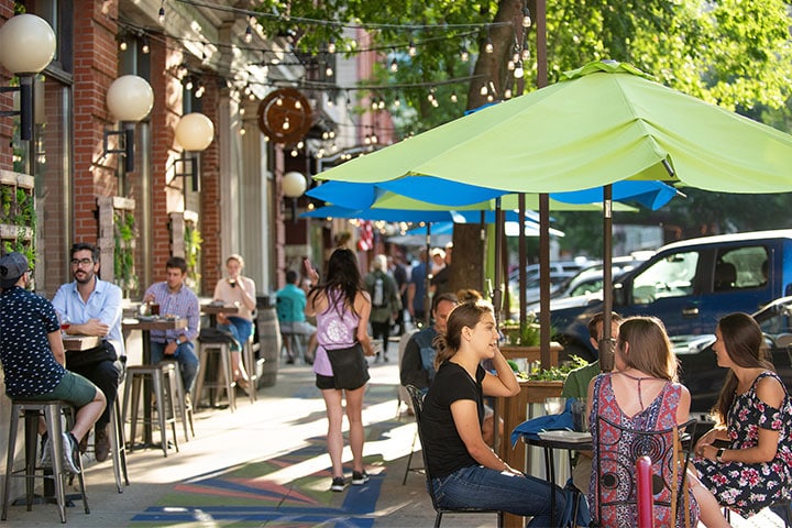 Community members dining on a sidewalk patio at a Rochester restaurant