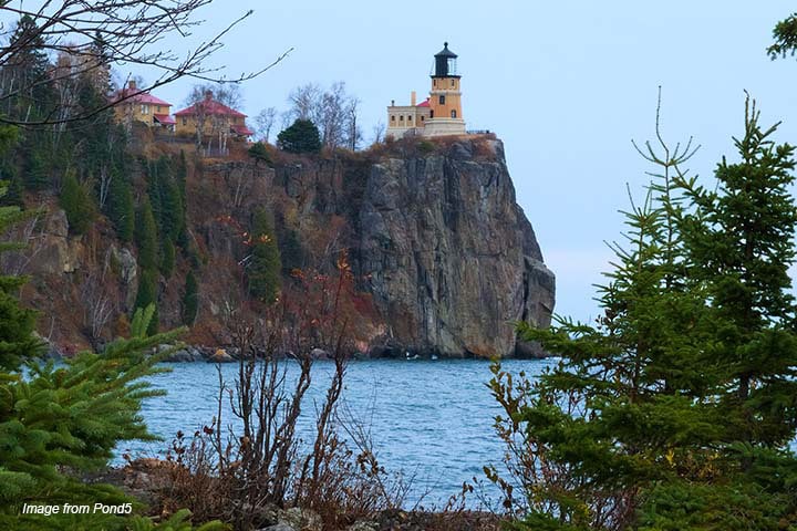 A lighthouse on a cliff side with water beneath in Minnesota