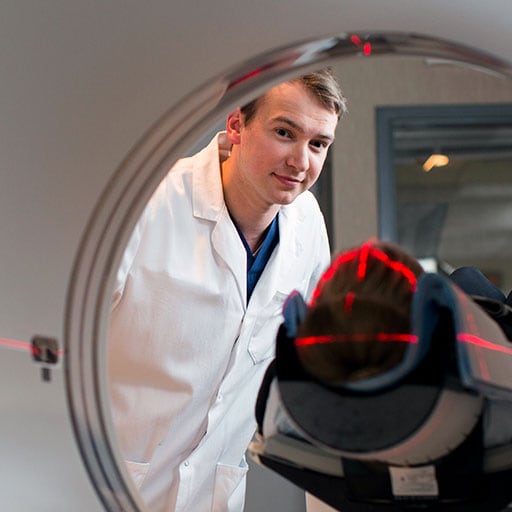 Mayo Clinic health sciences student placing a patient in an imaging scanner